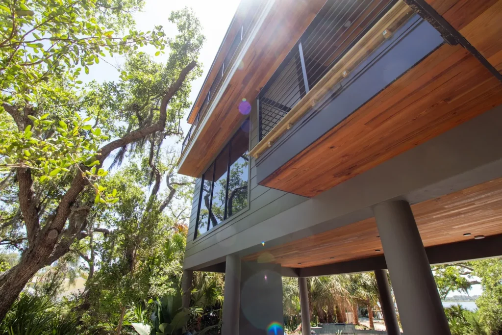 Expansive picture windows installed on a modern Florida home nestled in trees, by Freedom Windows & Doors